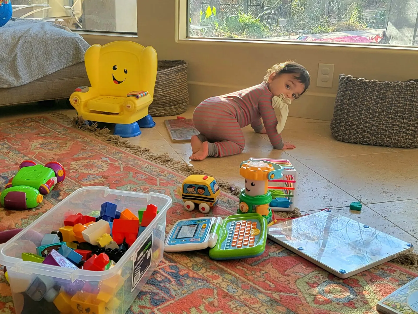 Enfant qui joue sur un tapis entouré de jouets